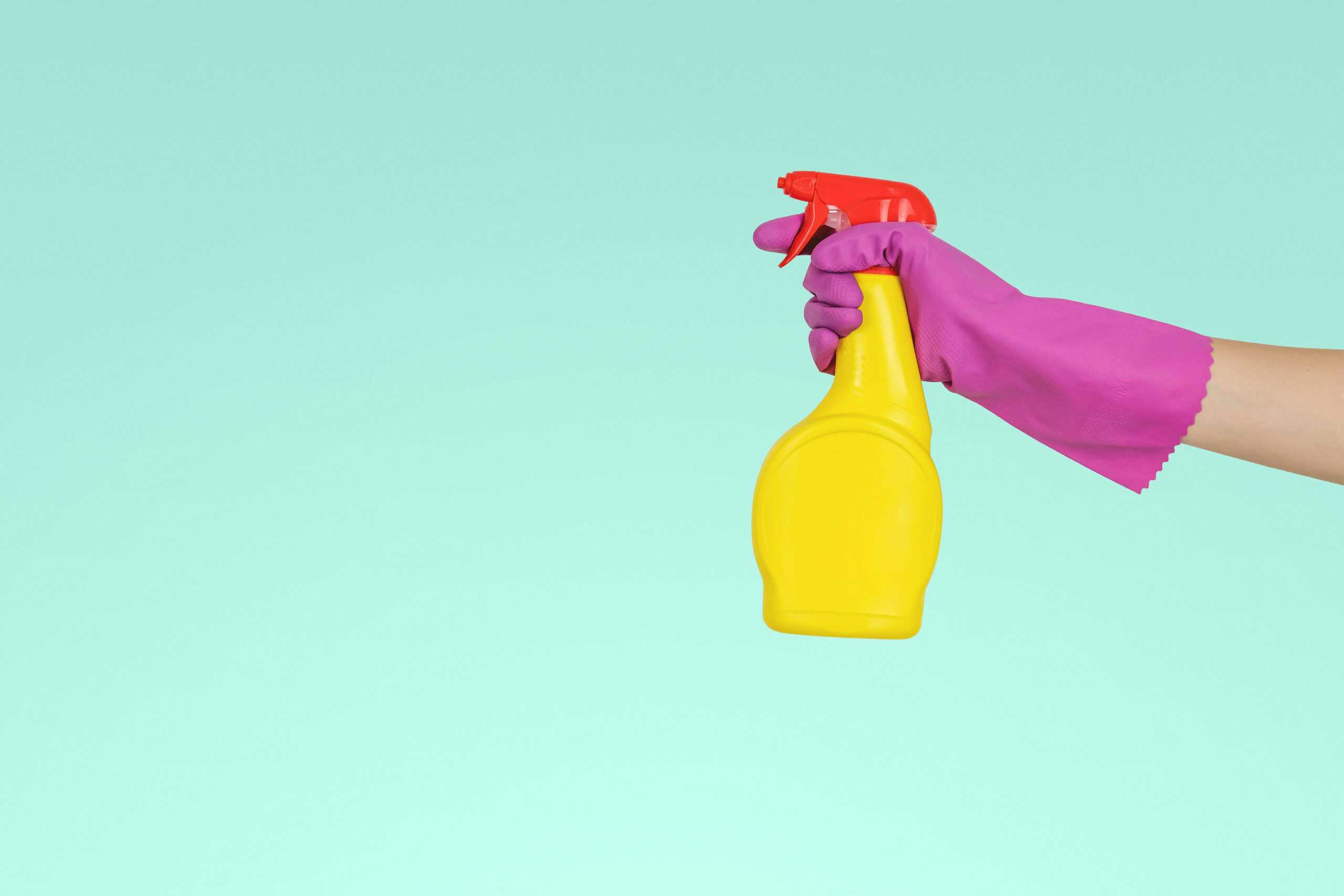 Spray bottle held by gloved hand